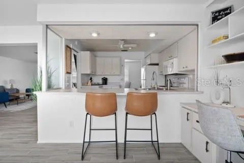 a kitchen with stainless steel appliances granite countertop a table chairs sink and cabinets