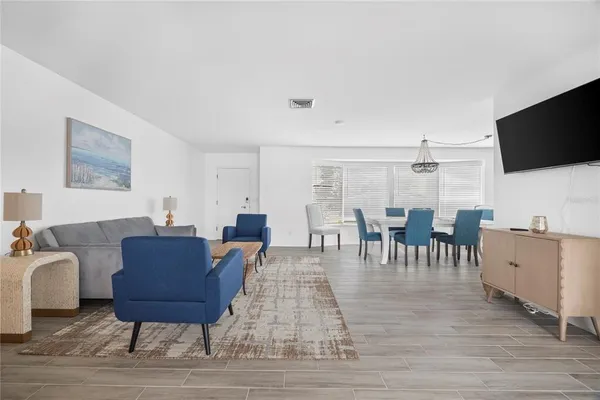 a living room with furniture a flat screen tv and kitchen view