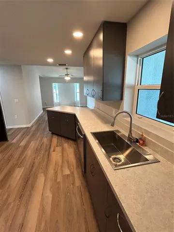 a kitchen with kitchen island granite countertop a sink and wooden floor