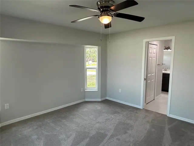 an empty room with a window and a fan