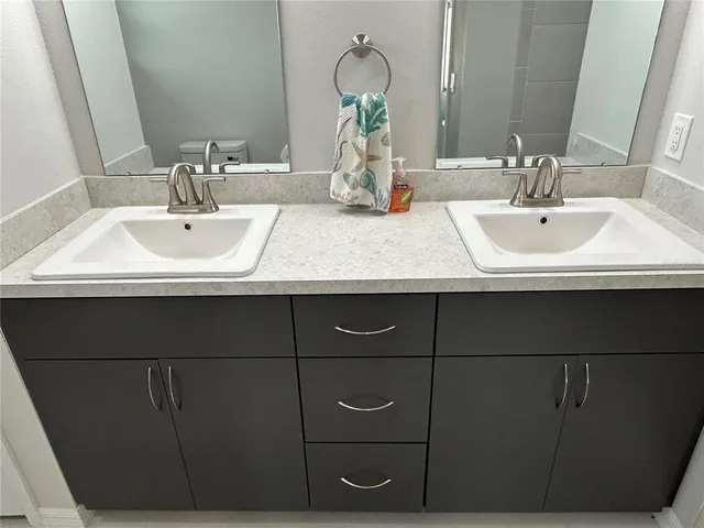 a bathroom with a granite countertop sink a shower and a mirror