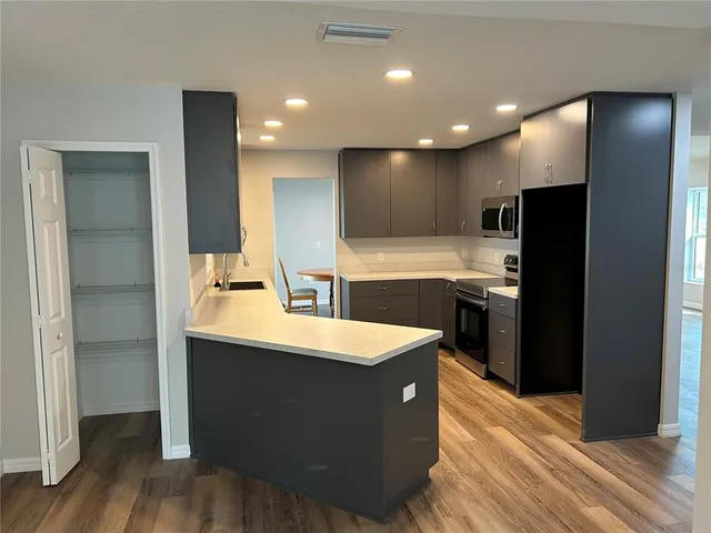 a kitchen with kitchen island sink stainless steel appliances and cabinets