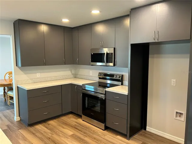 a kitchen with stainless steel appliances granite countertop a stove and a wooden cabinets