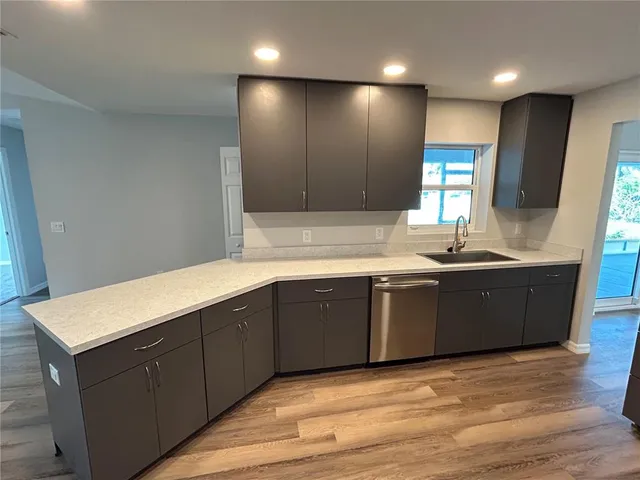 a kitchen with stainless steel appliances granite countertop wooden cabinets a sink and dishwasher