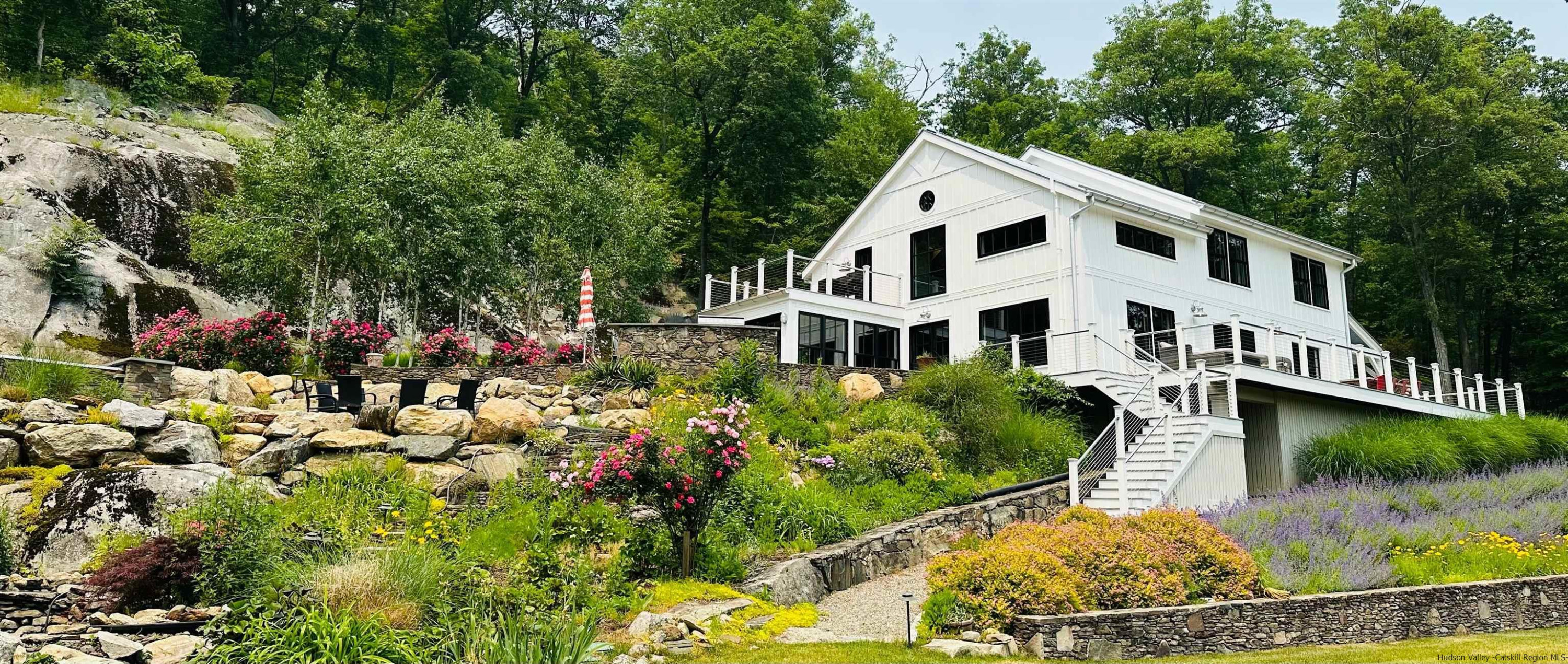 a view of white house with a yard and garden