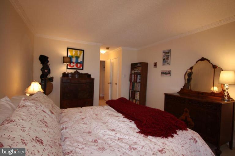 1045 31st Street Northwest, Unit 202 Washington, DC 20007 - Photo 13 of 21 a bedroom with a bed and a lamp on dresser