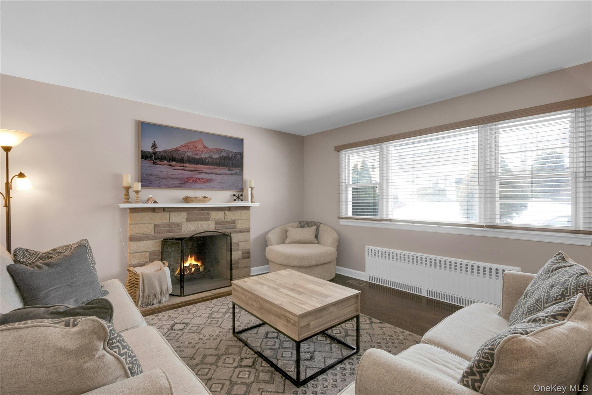 59 Sylvan Road Port Chester, NY 10573 - Photo 3 of 35 The living room features a fireplace and is bathed in bright light from a wall of windows