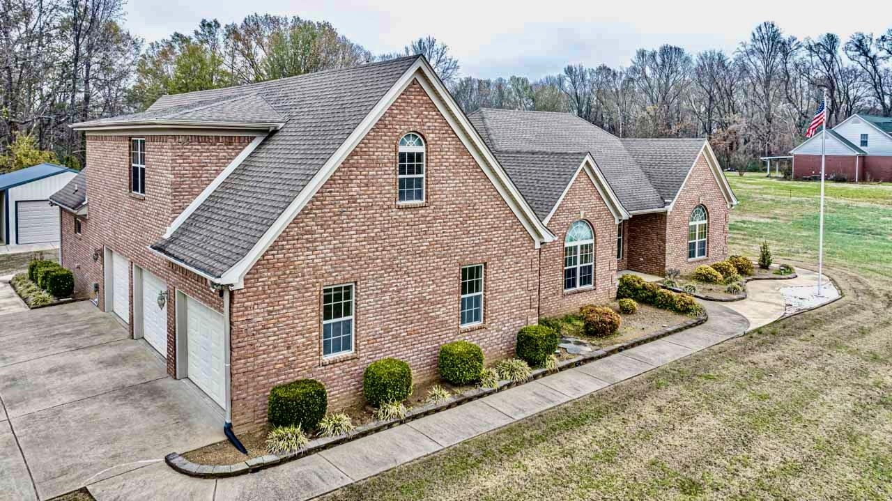 3876 West Union Road Millington, TN 38053 - Photo 16 of 40 Traditional home with a garage, brick siding, roof with shingles, and a front lawn