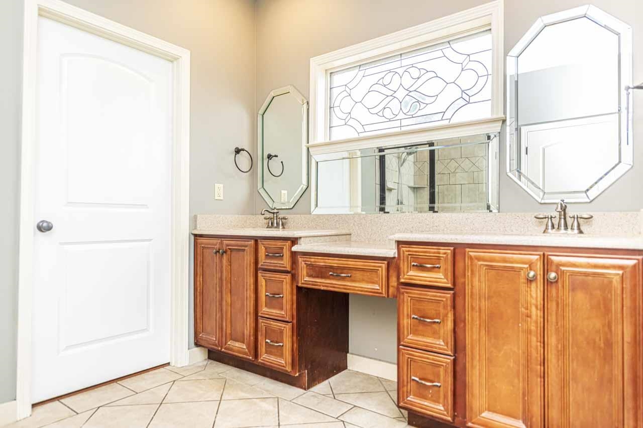 Bathroom with light tile patterned flooring and double vanity