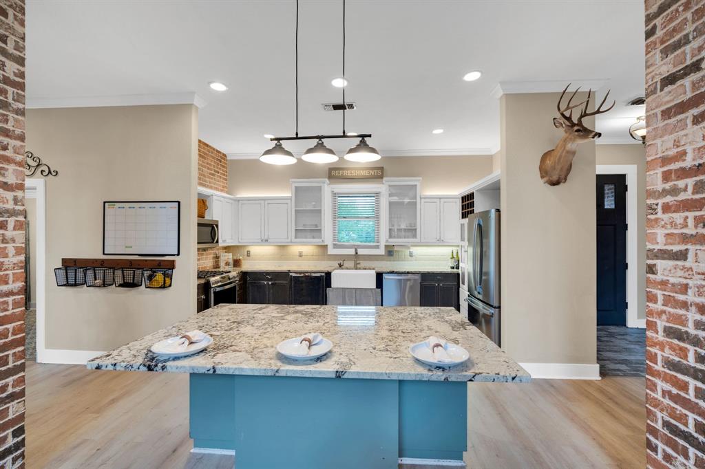 3052 Keri Lane Midlothian, TX 76065 - Photo 11 of 40 a large kitchen with kitchen island stainless steel appliances a stove center island a table and chairs