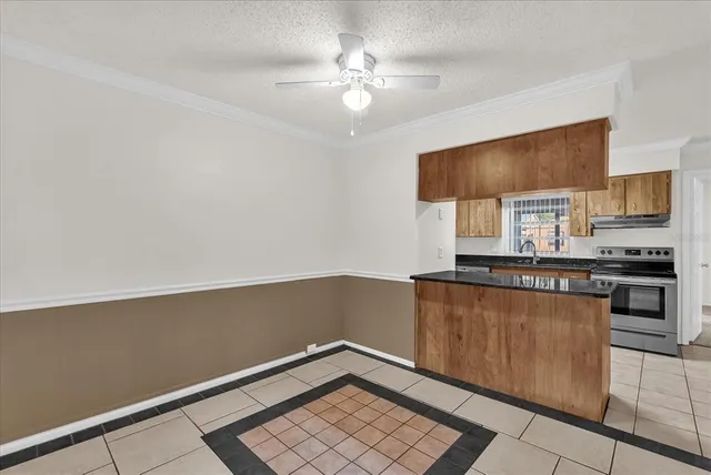 a kitchen with granite countertop a stove cabinets and microwave