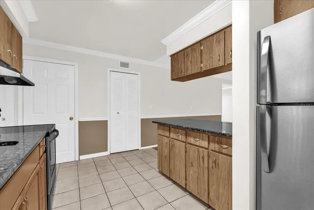 a kitchen with stainless steel appliances granite countertop a refrigerator and a sink