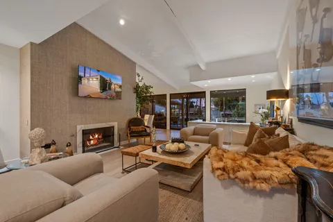 a living room with furniture a flat screen tv and a large window