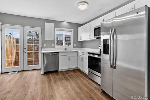 a kitchen with stainless steel appliances a refrigerator sink and cabinets