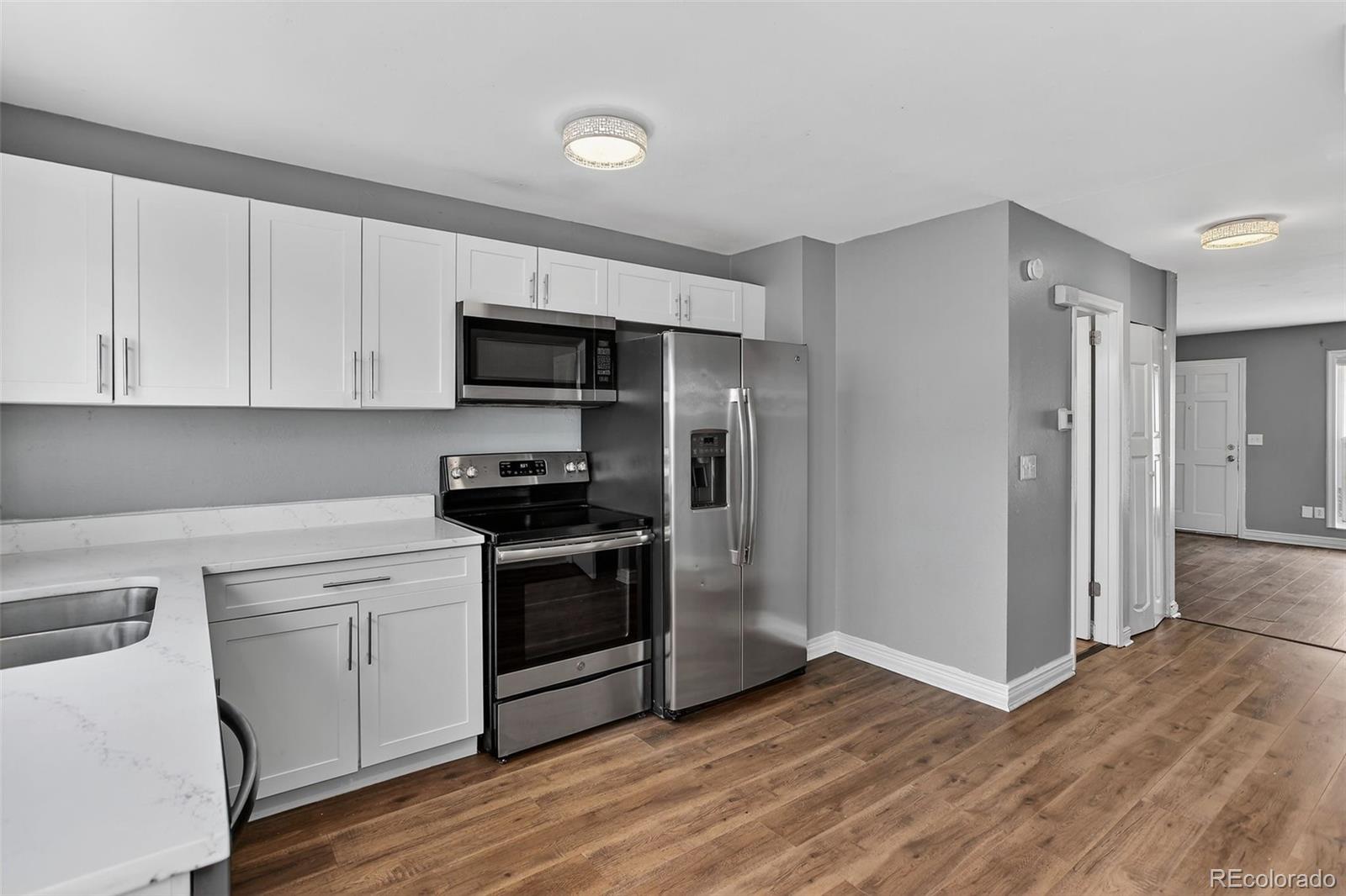 15771 East 13th Place Aurora, CO 80011 - Photo 3 of 11 a kitchen with granite countertop a stove and a refrigerator