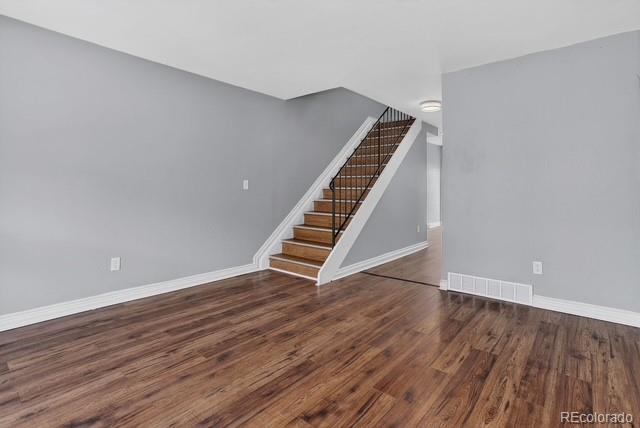 15771 East 13th Place Aurora, CO 80011 - Photo 7 of 11 a view of an empty room with wooden floor and stairs