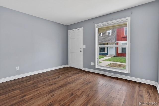 15771 East 13th Place Aurora, CO 80011 - Photo 8 of 11 a view of an empty room with wooden floor and a window