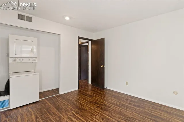 a view of an empty room with closet and a window