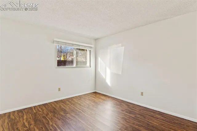 an empty room with wooden floor and window