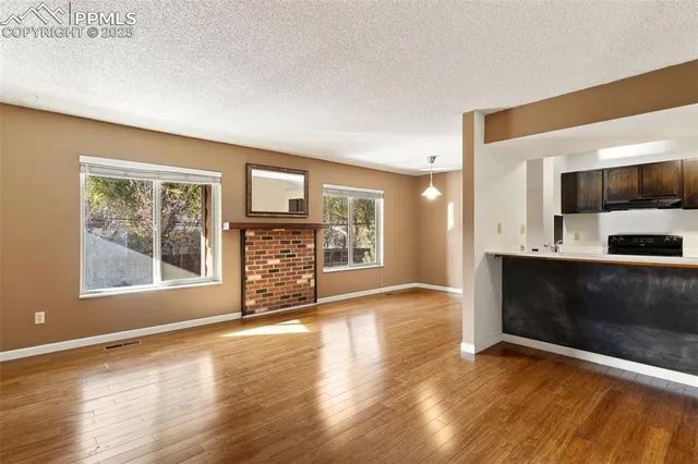 a view of an empty room with a fireplace and a window
