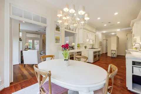 a large white kitchen with stainless steel appliances kitchen island granite countertop a sink and cabinets