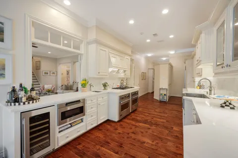 a hallway with wooden floors and cabinet