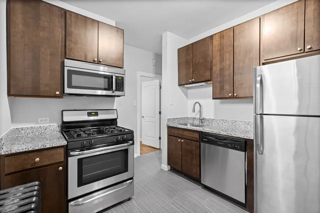 a kitchen with granite countertop a sink stove and refrigerator