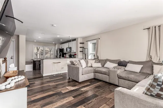 a living room with furniture and a view of kitchen