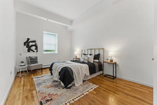 a bedroom with a bed and wooden floor