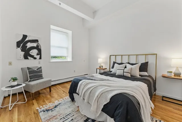 a bedroom with a bed and wooden floor