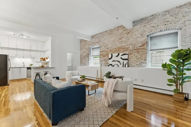 a living room with furniture and a potted plant