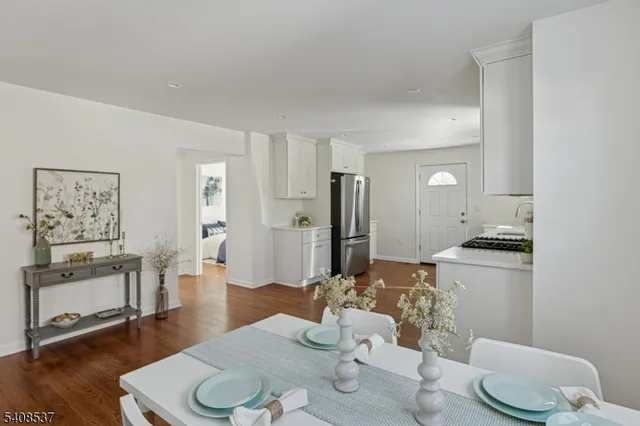 a kitchen with stainless steel appliances kitchen island granite countertop a refrigerator and wooden floor