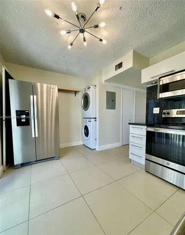 a view of a kitchen with a sink and a refrigerator