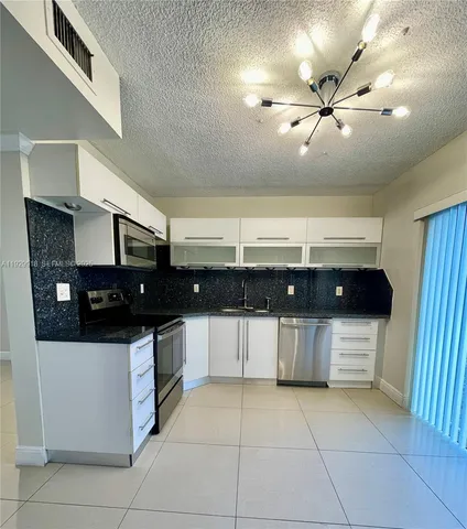 a kitchen with stainless steel appliances a sink and cabinets