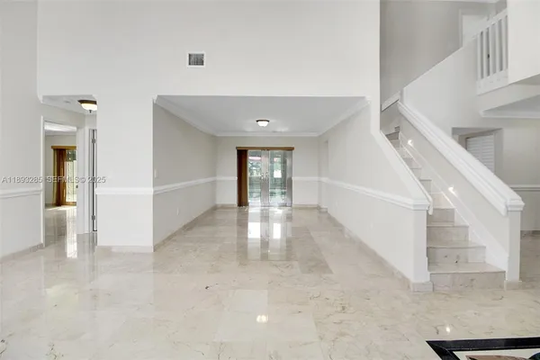 a view of a hallway with cabinet and chandelier