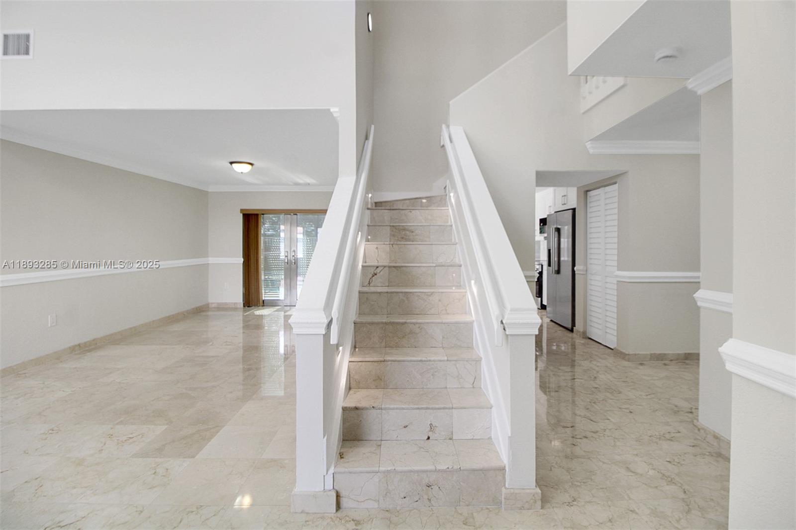 8416 Northwest 201st Street Hialeah, FL 33015 - Photo 15 of 40 Lit stairway to second level. On the left is the formal dining room and on the right is the walkway to the newly remodeled kitchen or the huge family room.