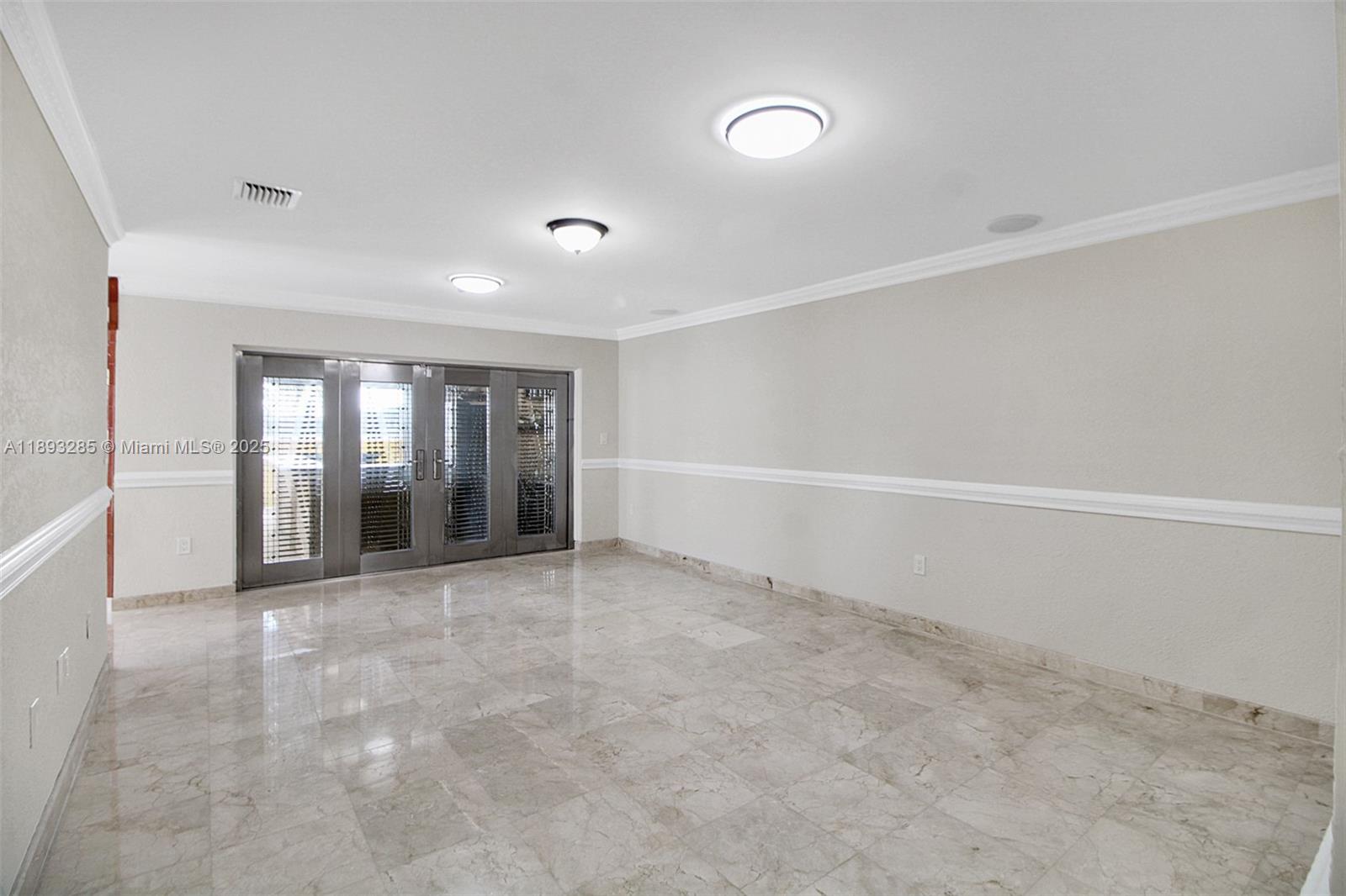 8416 Northwest 201st Street Hialeah, FL 33015 - Photo 16 of 40 Family room looking out towards the summer kitchen. On the left is the entranceway to the kitchen. The doors are security doors imported from Mexico. They have intricate grills between the glass panes.
