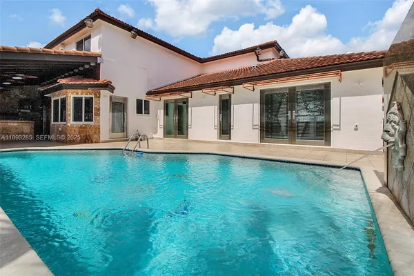 a view of a house with pool and sitting area