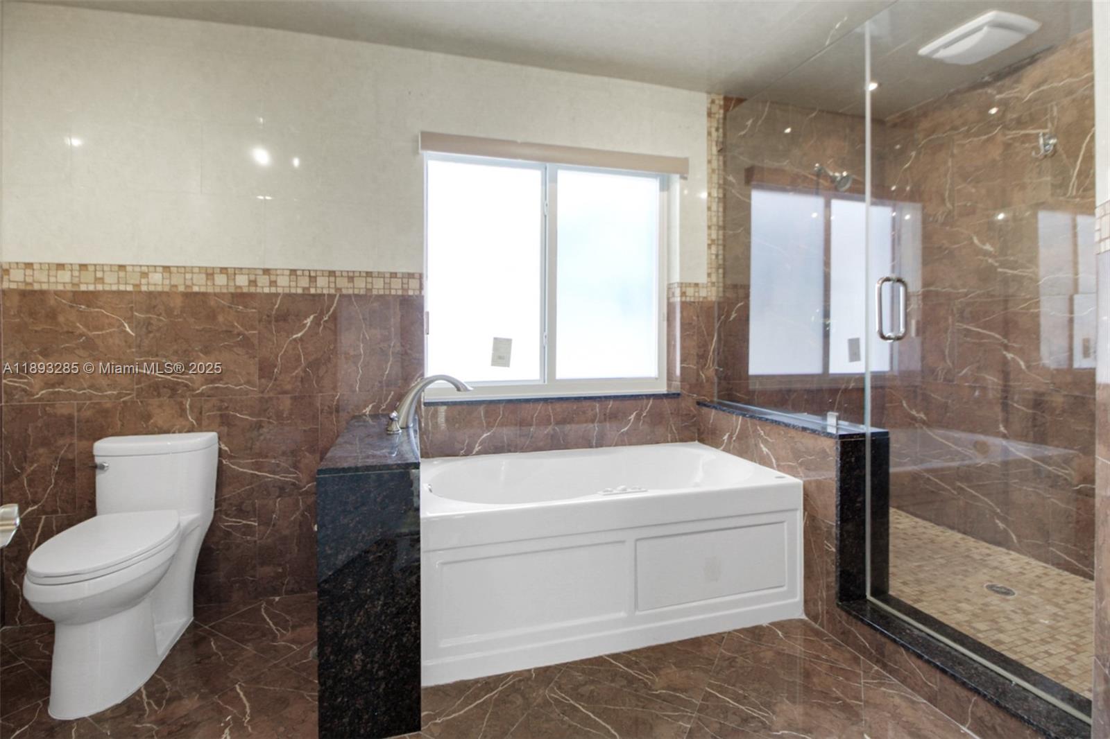 8416 Northwest 201st Street Hialeah, FL 33015 - Photo 21 of 40 Primary bedroom has a jetted tub and large shower with two shower heads.