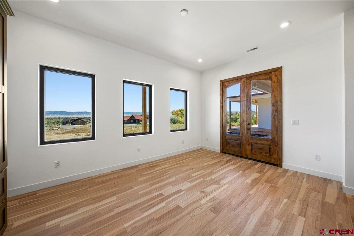 14447 5950 Road Montrose, CO 81403 - Photo 12 of 45 a view of an empty room with window and wooden floor