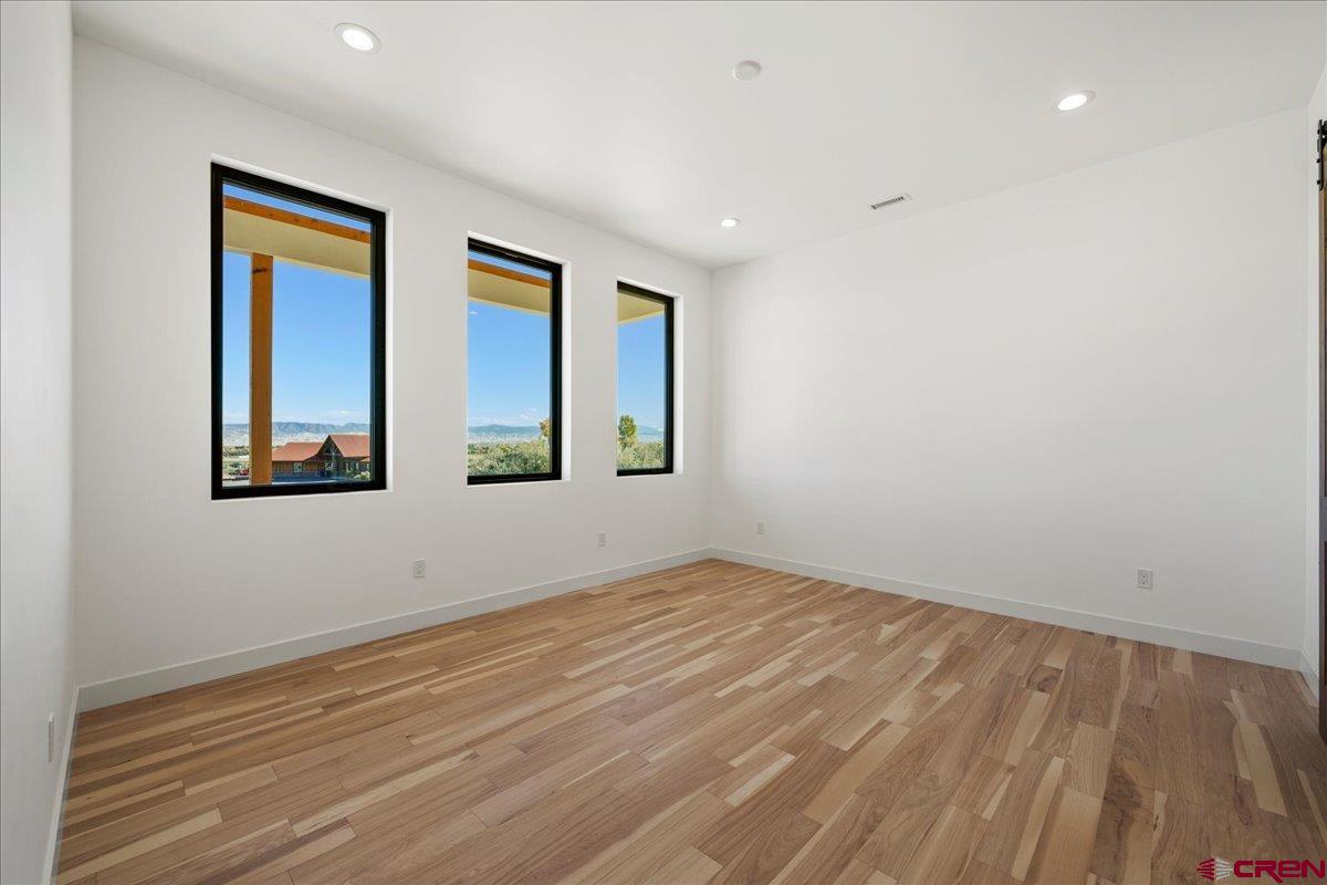 14447 5950 Road Montrose, CO 81403 - Photo 16 of 45 a view of an empty room with wooden floor and a window