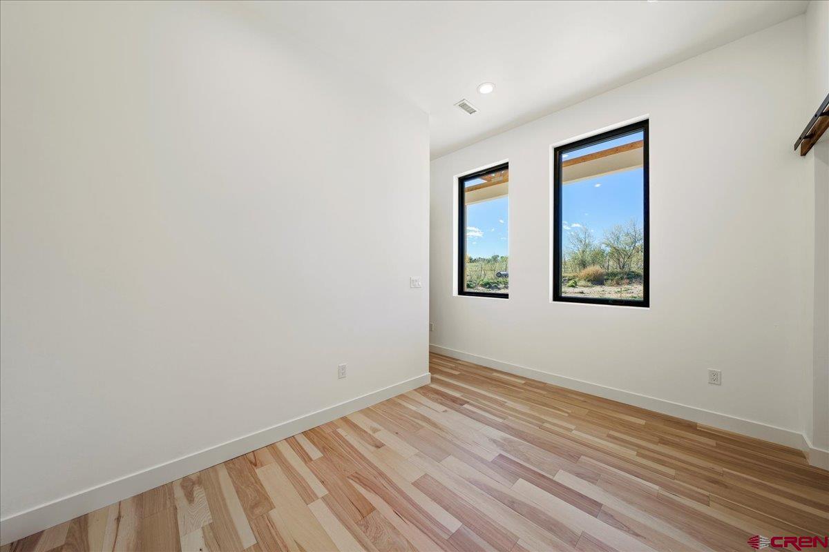 14447 5950 Road Montrose, CO 81403 - Photo 24 of 45 a view of an empty room with wooden floor and a window
