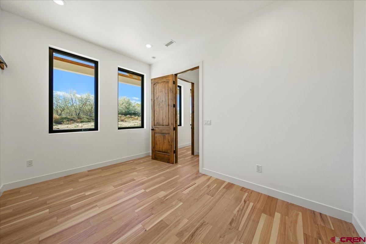 14447 5950 Road Montrose, CO 81403 - Photo 26 of 45 a view of an empty room with window and wooden floor