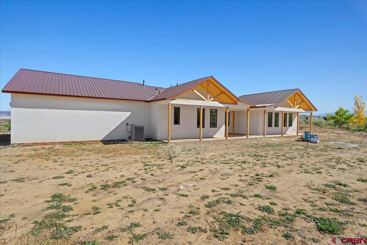 14447 5950 Road Montrose, CO 81403 - Photo 35 of 45 a yellow house with a wooden fence