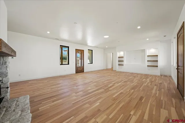 a view of empty room with kitchen and window