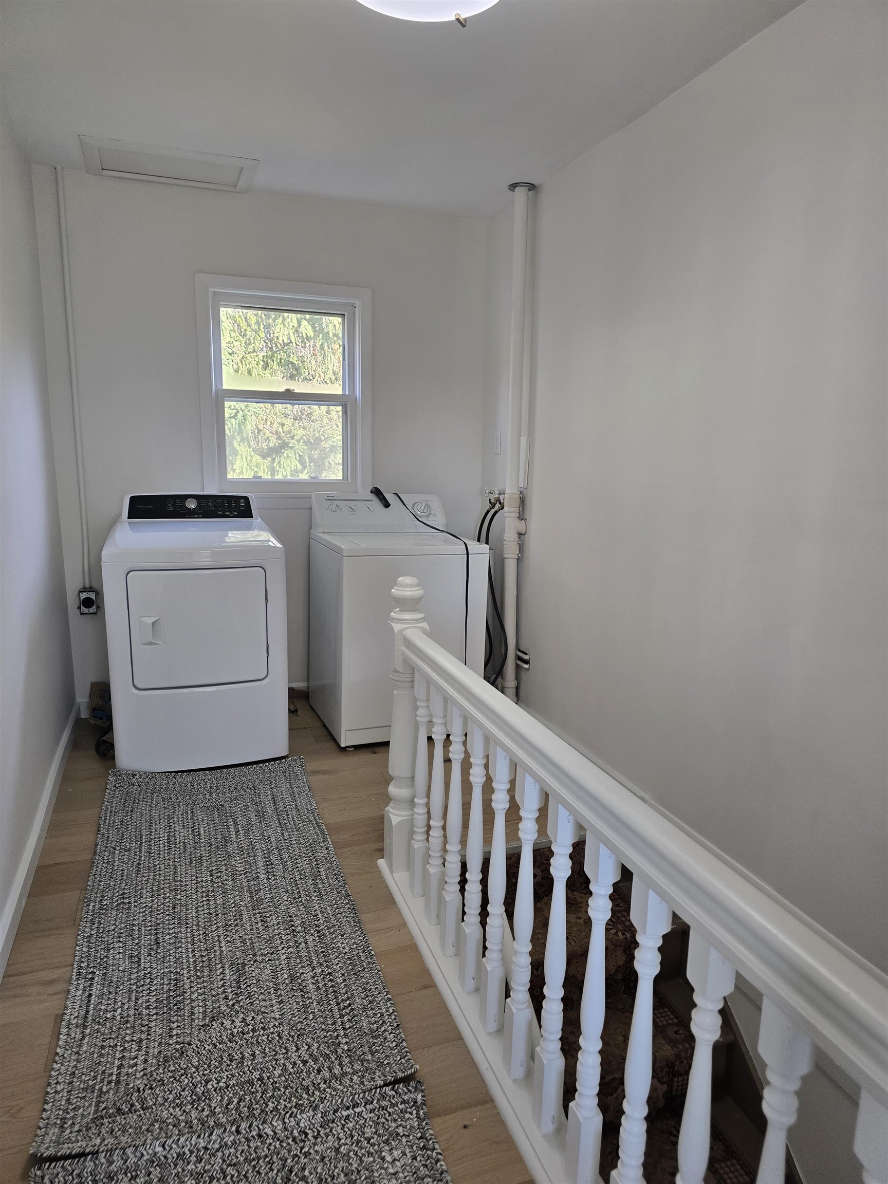 321 Rice Avenue Bayfield, WI 54814 - Photo 16 of 30 Clothes washing area for upper unit with engineered hardwood floors and independent washer and dryer