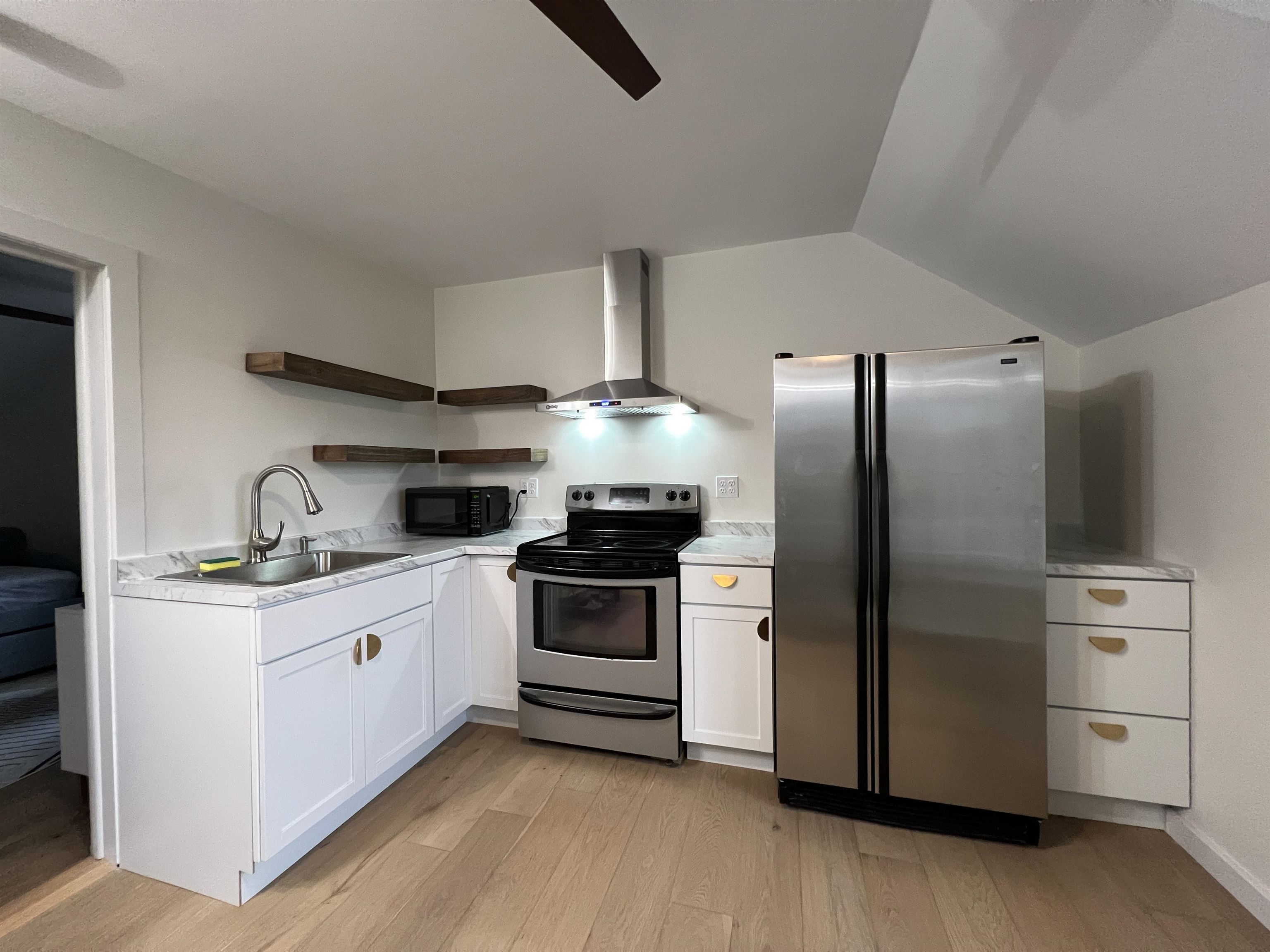 321 Rice Avenue Bayfield, WI 54814 - Photo 17 of 30 Kitchen with stainless steel appliances, white cabinets, open shelves, light countertops, and light wood-type flooring