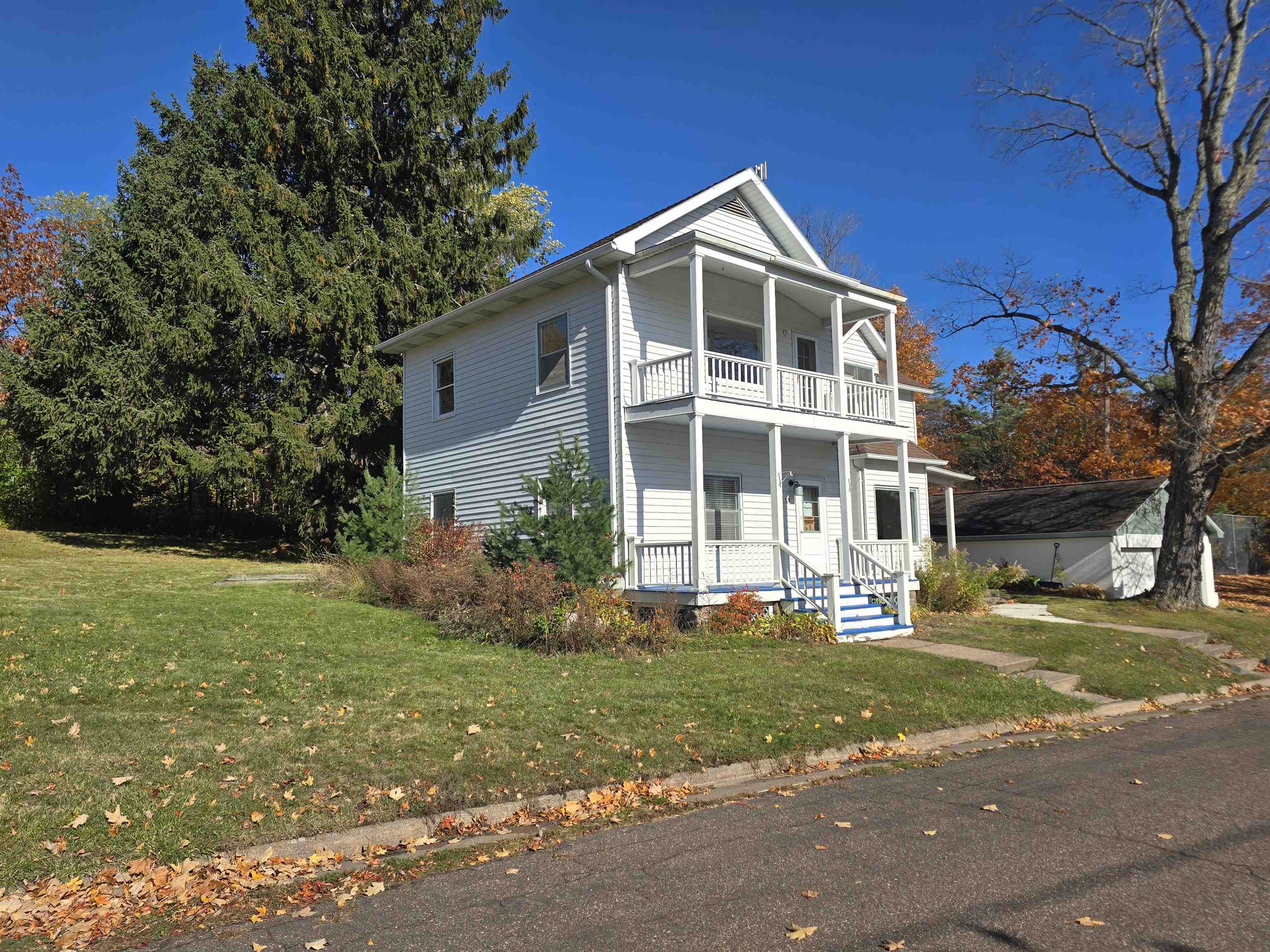 321 Rice Avenue Bayfield, WI 54814 - Photo 3 of 30 View of front of home featuring a porch, a front lawn, and a balcony