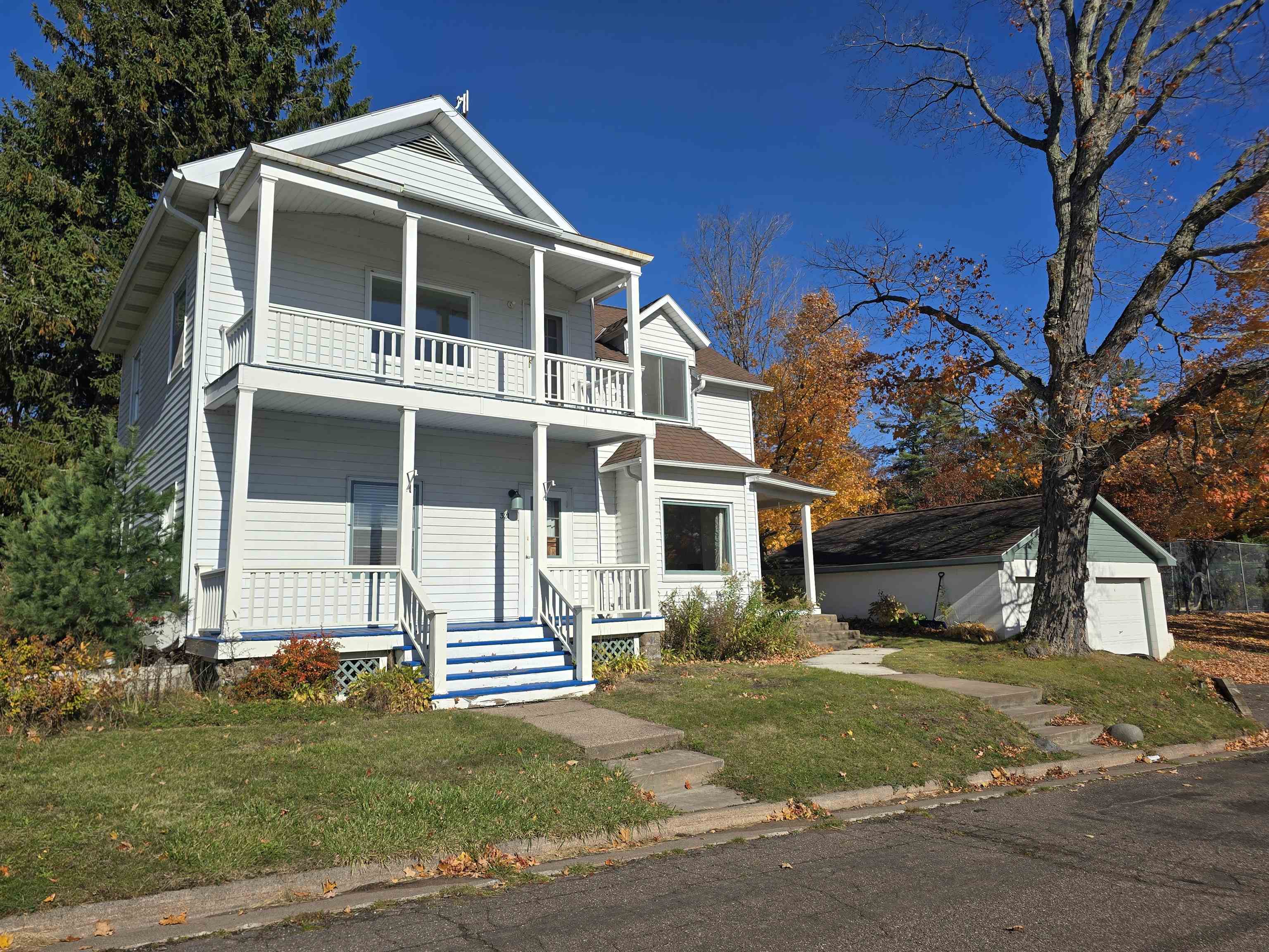321 Rice Avenue Bayfield, WI 54814 - Photo 5 of 30 View of front of property with covered porch, a front yard, an outbuilding, and a garage