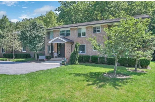 a view of a house with a yard and large tree